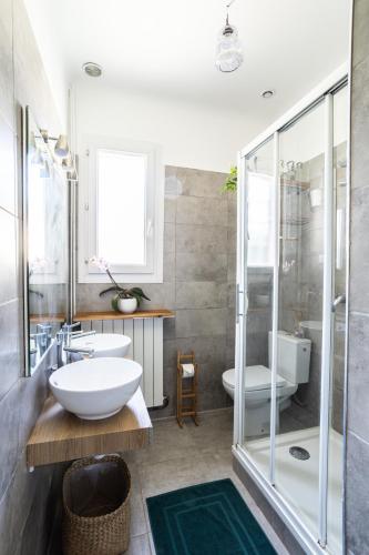 a bathroom with two sinks and a glass shower at Villa Philipp'inn in Arles