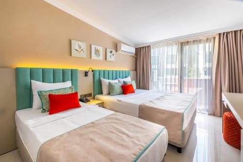 a hotel room with two beds and a window at Rose Garden Premium - Ultra All Inclusive in Kemer