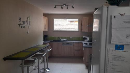 une cuisine avec un réfrigérateur et une table à l'intérieur dans l'établissement AGREABLE T4 centre D'AX-LES-THERMES, à Ax-les-Thermes