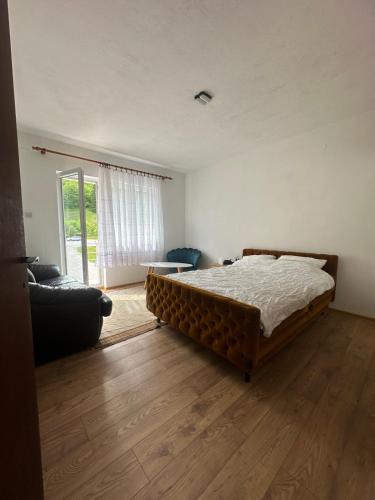 a bedroom with a bed and a living room with a couch at Mirina village house in Pljevlja