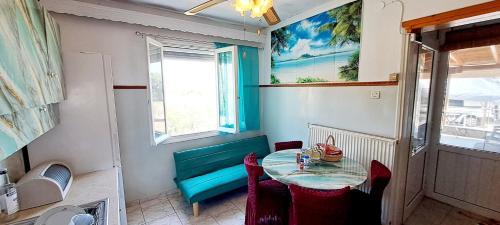 a small dining room with a table and a blue bench at SUN and Sea HOUSE Kavala ammolofoi αμμόλοφοι in Eleftheres