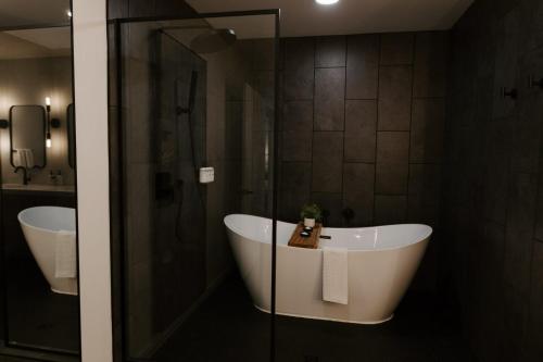 a bathroom with a tub and a shower and a sink at Nature Link Resorts in Nisswa