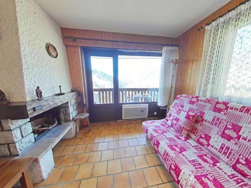 un salon avec un canapé et une cheminée dans l'établissement Appt cosy 3 pièces avec cheminée, proche télécabine - FR-1-241-42, au Grand-Bornand