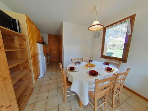 une cuisine et une salle à manger avec une table et des chaises dans l'établissement Appt T3 au centre, terrasse sud, proche commerces - FR-1-241-169, au Grand-Bornand