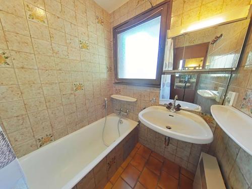 La salle de bains est pourvue d'un lavabo et d'une baignoire. dans l'établissement Appt cosy 3 pièces avec cheminée, proche télécabine - FR-1-241-42, au Grand-Bornand