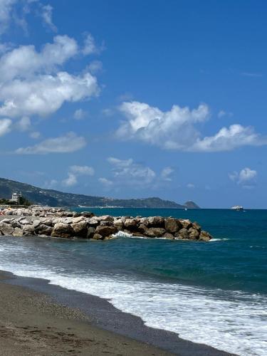 a beach with a group of rocks in the water at Casa Rosy Sicilia in Brolo