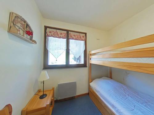 une chambre avec deux lits superposés et une fenêtre dans l'établissement Appt rénové 3 pièces, 6 couchages, proche centre, ascenseur, lave-vaisselle, lave-linge - FR-1-241-35, au Grand-Bornand