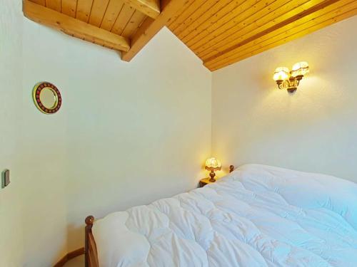 - une chambre avec un lit blanc et un plafond en bois dans l'établissement Appt cosy 5 pers, 300m centre, parking, animaux admis - FR-1-241-85, au Grand-Bornand
