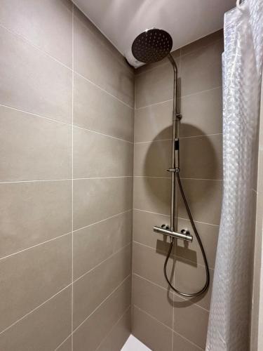 una ducha con cabezal de ducha en un baño en La case sénégalaise, en Cholet