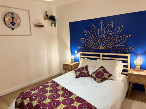 une chambre avec un grand lit avec un mur bleu dans l'établissement La case sénégalaise, à Cholet