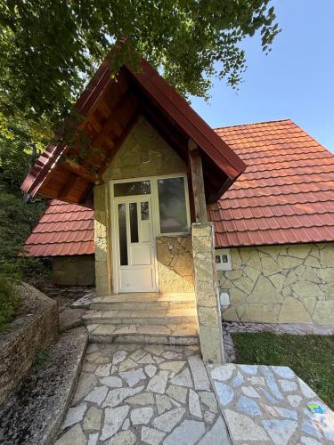a small house with a red roof and a door at Guest house Crvenkapa in Gusinje