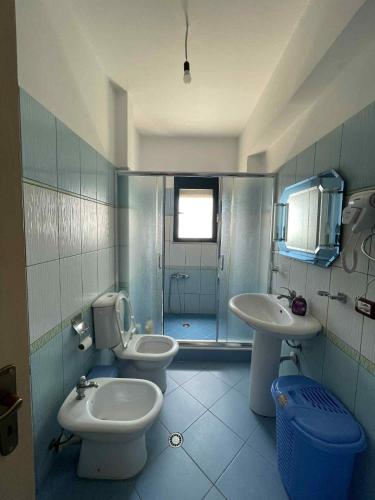 a bathroom with two toilets and a sink at Klara's Apartment in Fier