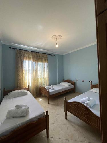 a bedroom with two beds and a window at Klara's Apartment in Fier