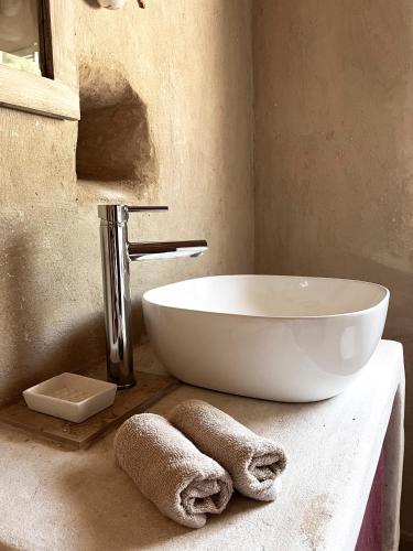 a bathroom with a sink and towels on a counter at La casetta La Vita in land in Burgio