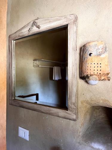 a mirror on the wall of a bathroom at La casetta La Vita in land in Burgio