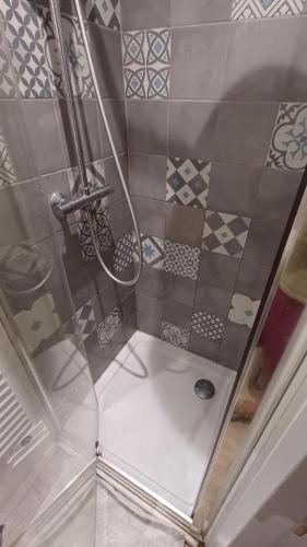 une douche dans une salle de bain avec un sol carrelé dans l'établissement Priv'8Spa Love Room Jacuzzi & Terrasse - Amour, Détente et Intimité, à Toulouse