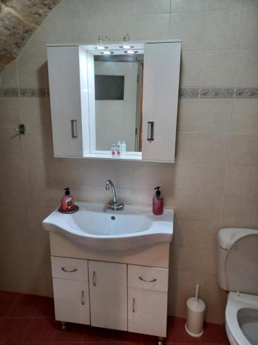 a bathroom with a sink and a mirror and a toilet at Rethymno traditional Studio in Rethymno Town