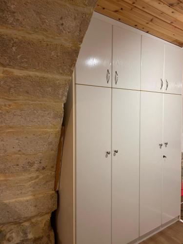 a room with white cabinets and a brick wall at Rethymno traditional Studio in Rethymno Town