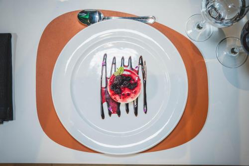 a white plate with a strawberry on a table at Holiday Inn Rosario by IHG in Rosario