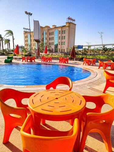 a table and chairs in front of a swimming pool at Ramage Hotel & Resort in Cairo