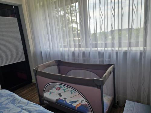 a baby crib sitting in front of a window at Filder Apartment in Ostfildern