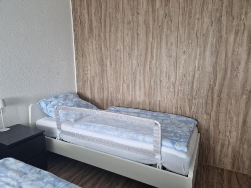 two twin beds in a room with wooden walls at Filder Apartment in Ostfildern