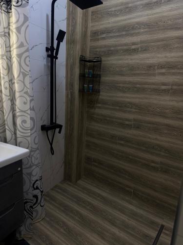 a shower in a bathroom with a wooden floor at AlenAr Hotel in Yerevan