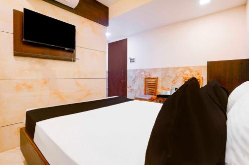 a bedroom with a bed and a tv on a wall at Hotel O Kalyan East in Mumbai