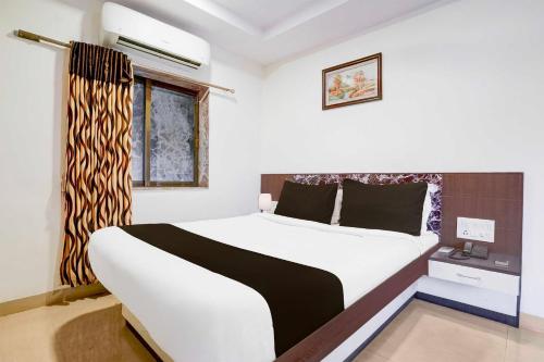 a bedroom with a large bed and a window at Hotel O Mahableshwar Uptown in Mahabaleshwar
