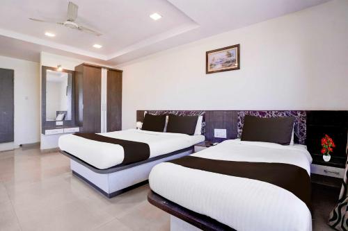 a hotel room with two beds and a window at Hotel O Mahableshwar Uptown in Mahabaleshwar