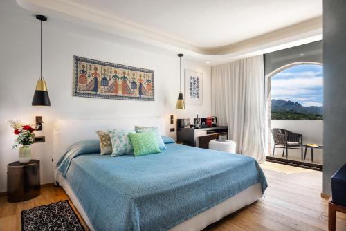 a bedroom with a blue bed and a window at Hotel delle Rose a Luxury Boutique Hotel in Porto Cervo