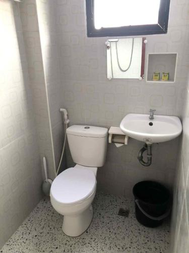 a small bathroom with a toilet and a sink at ZM Residence in Dapa