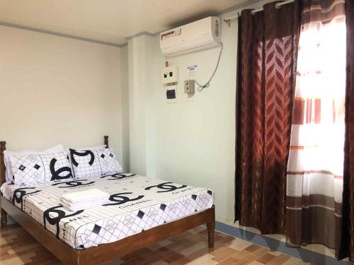 a bedroom with a bed and a air conditioner at ZM Residence in Dapa