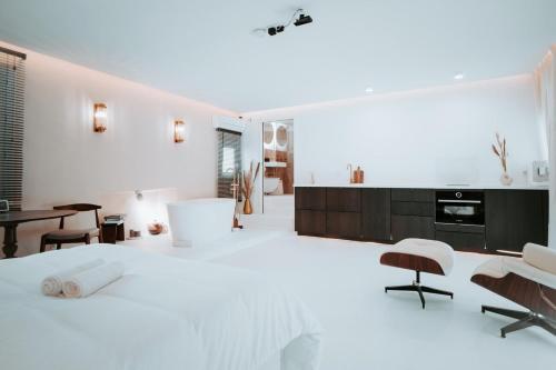 une chambre blanche avec un grand lit et une table dans l'établissement Love & Balneo Week-End, à Marseille