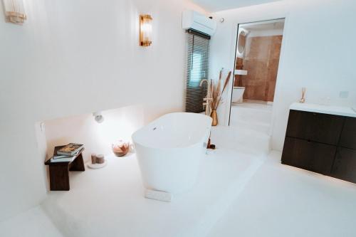 a white bathroom with a tub and a sink at Love & Balneo Week-End in Marseille
