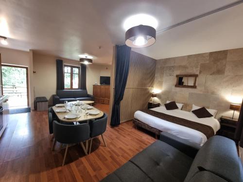 une chambre d'hôtel avec un lit, une table et des chaises dans l'établissement Camper au Moulin de la brevette, à Arbigny