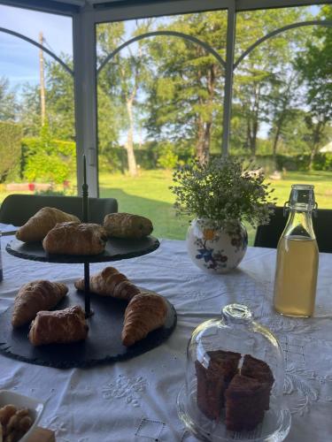 une table garnie d'assiettes de pâtisseries et d'une bouteille de lait dans l'établissement Le Clos de Kerhouil, à Sainte-Anne-d'Auray