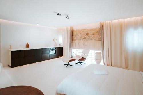 a white bedroom with a bed and two chairs at Love & Balneo Week-End in Marseille