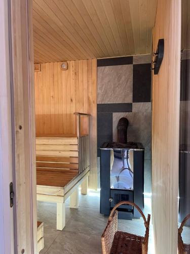 a room with a sauna with a bench and a stove at Карпатська Модрина in Kosiv
