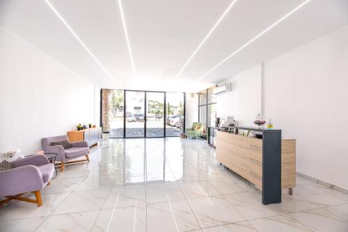 a large room with a lobby with tables and chairs at Stone Palace Hotel Near Athen's Airport Free Shuttle From and to Athen's Airport in Spáta