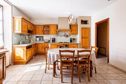 une cuisine avec des armoires en bois et une table avec des chaises dans l'établissement Large house in southern Burgundy, à Lalheue