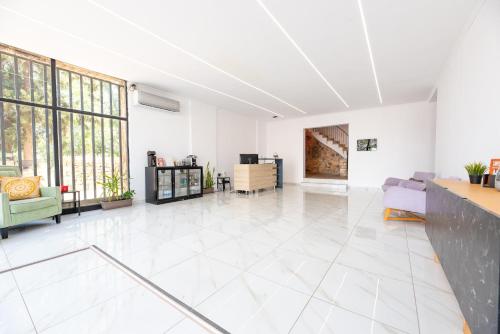 a large living room with white tile floors and windows at Stone Palace Hotel Near Athen's Airport Free Shuttle From and to Athen's Airport in Spáta