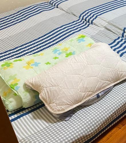 a bed with a pillow on top of it at Joyful Rose in Ginowan