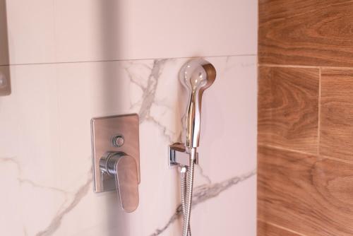 a shower in a bathroom with a shower head at Stone Palace Hotel Near Athen's Airport Free Shuttle From and to Athen's Airport in Spáta