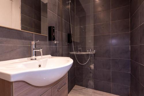 a bathroom with a sink and a shower at Stone Palace Hotel Near Athen's Airport Free Shuttle From and to Athen's Airport in Spáta