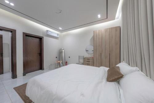 a white bedroom with a large white bed in it at Alzahraa Studio in Jeddah