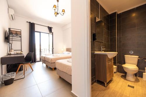 スパタにあるStone Palace Hotel Near Athen's Airport Free Shuttle From and to Athen's Airportのベッドルーム(ベッド1台、シンク、トイレ付)