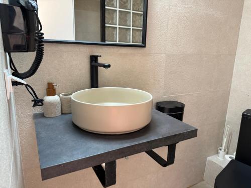 a bathroom with a large bowl sink on a counter at Amelia Seaview Apartments & Studios in Kallithea Halkidikis