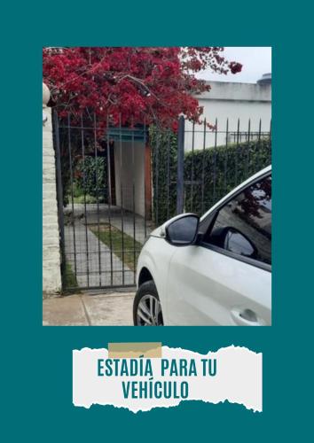 a white car parked next to a fence at Nel's Casa Hostel A 15 minutos de Aeropuerto Ezeiza in Monte Grande