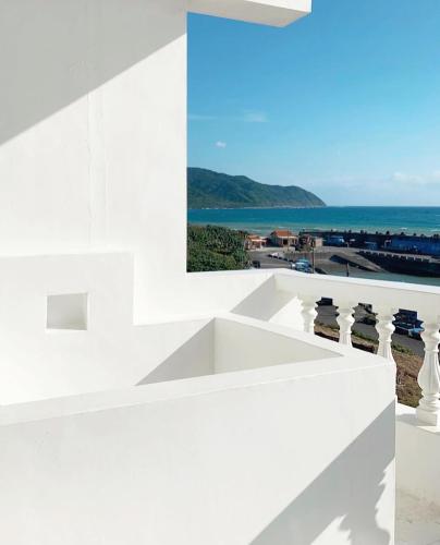 a view of the ocean from the balcony of a white building at White&Light B&B in Manzhou